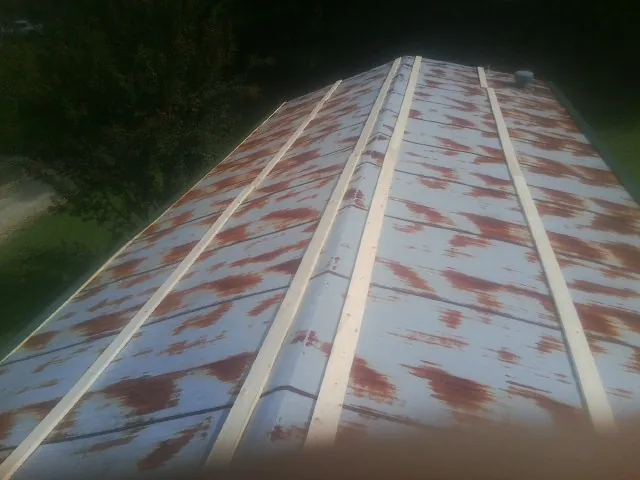 Rusted metal roof panels with new wood purlins before replacement — Storm Damage Roof Repair in Rudd by Roofing Brothers